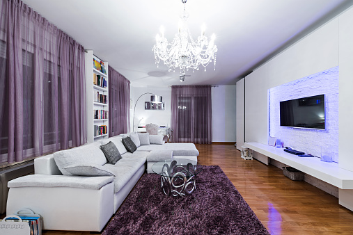 Modern apartment interior of a living room in white and purple tones