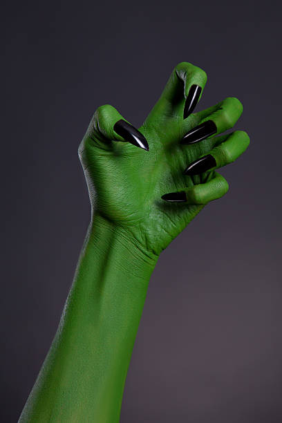 green hexe hand mit eleganten schwarzen nägeln, real body-art - green monster stock-fotos und bilder
