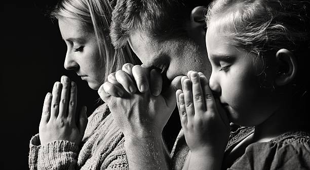Praying family. Man, woman and child. Praying family. Man, woman and child. church black and white people praying stock pictures, royalty-free photos & images