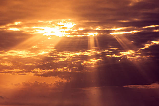 sunset sky with light rays Beautiful orange sunset sky with light rays going through clouds easter sunday photos stock pictures, royalty-free photos & images