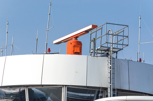 Air traffic control tower with radar equipment at an airport.