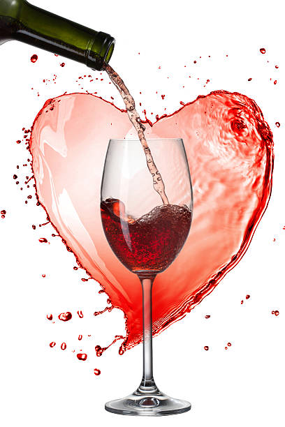 istock Red wine pouring into glass with splash against heart isolated 469518043