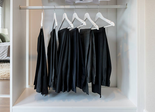 istock row of pants hanging on coat hanger in white wardrobe 469520824