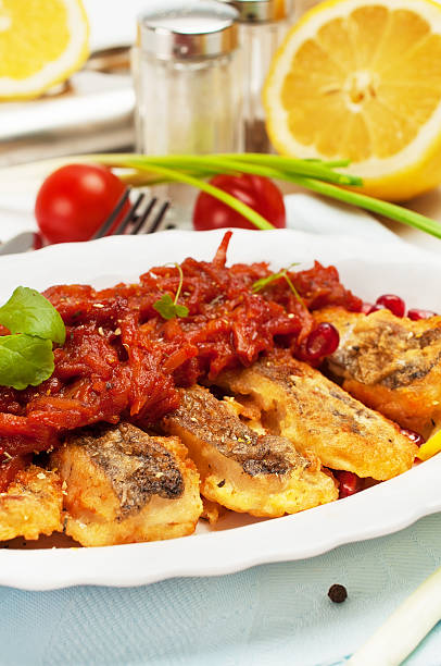 istock Pieces of fried fish with vegetable sauce. 469522265