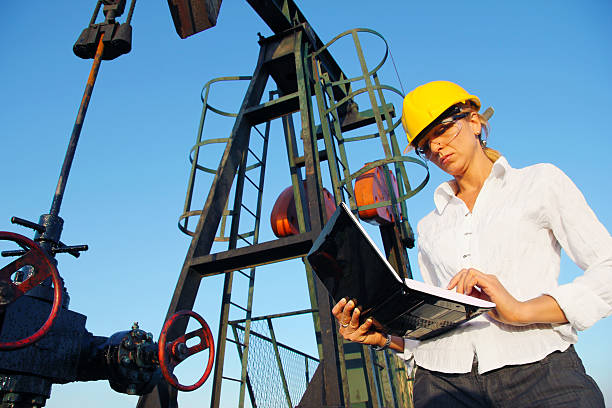 mulher de negócios com um bloco de notas em um dos campos petrolíferos - oil business - fotografias e filmes do acervo