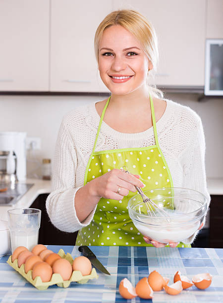 istock Housewife beating eggs and milk in bowl 469529424