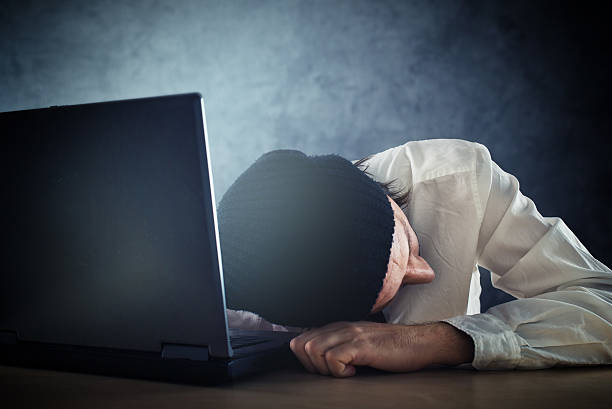 istock Exhausted man sleeps on laptop at office desk 469531947