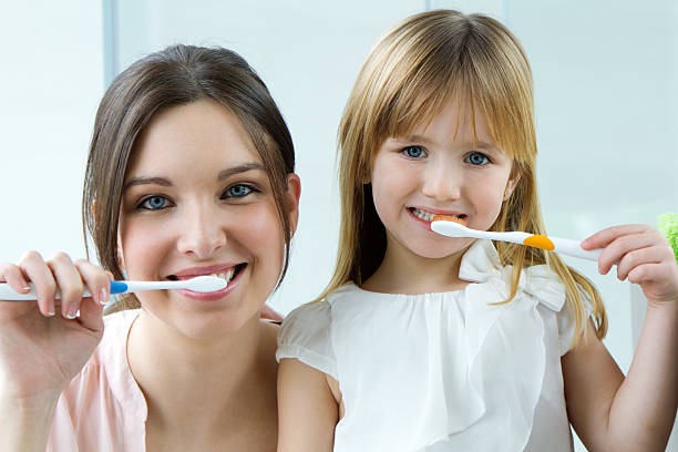 istock Mother and daughter brushing teeth in the bathroom 469536755