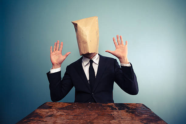 istock Startled businessman with bag over head raising his hands 469537881