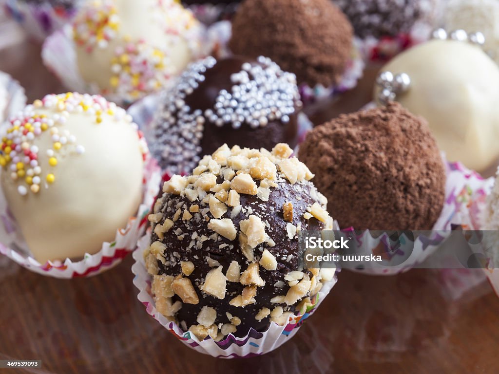 Homemade sweet little party cakes Small pastry truffle with different icing and decoration. Almond Stock Photo