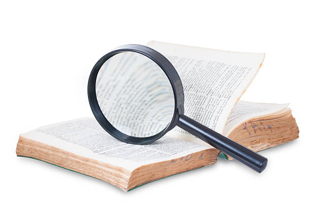 istock Magnifying glass and old book, isolated on white 469539179