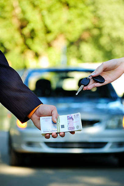 Car sale The seller changes keys for money. Car sale cash for cars stock pictures, royalty-free photos & images