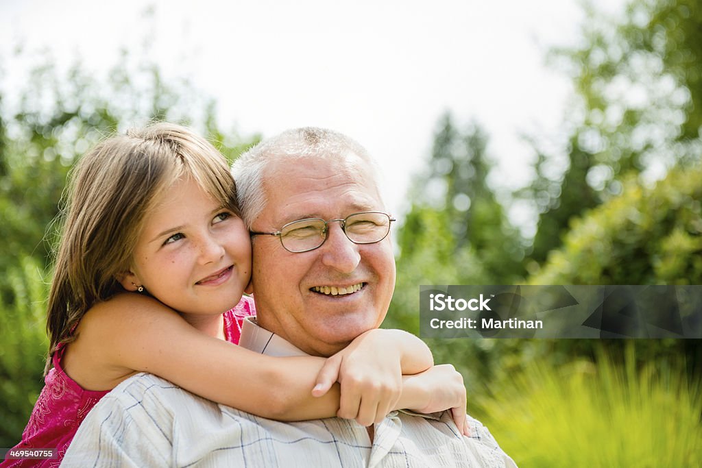Happy grandfather with grandchild Outdoor lifestyle portrait of grandchild embracing grandfather Two People Stock Photo