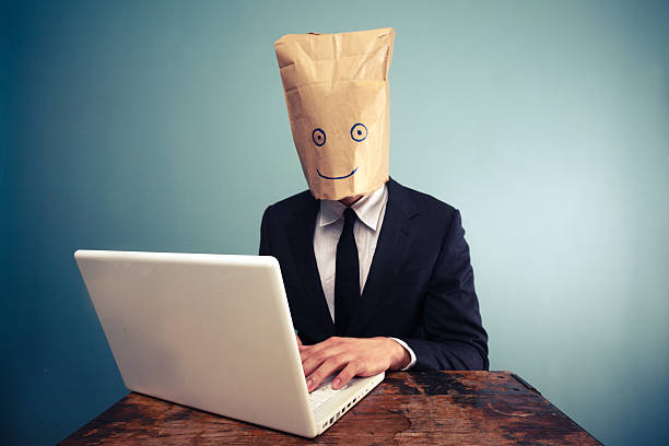 istock Businessman with bag over head working on computer 469541359