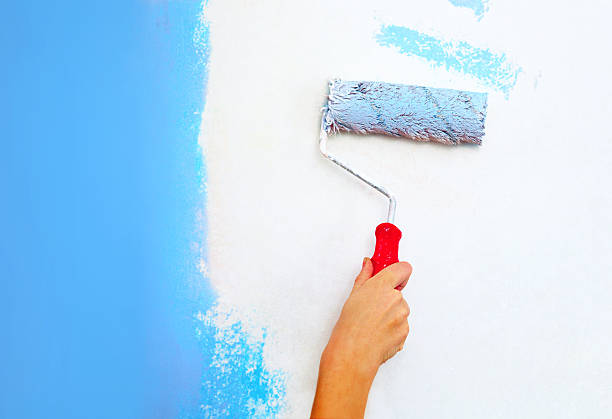 istock Hand with roller brush painting wall. 469541407