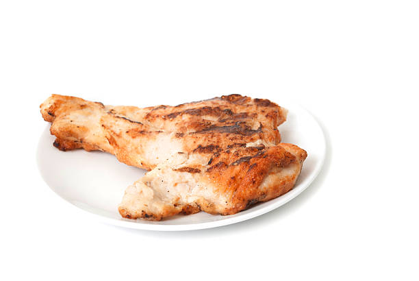 Homemade delicious grilled barbecue chicken with cut pieces of Paratha and tomato sauce served on a ceramic plate on a wooden background. Tasty Bengali-style roasted chicken, a nutritious food.