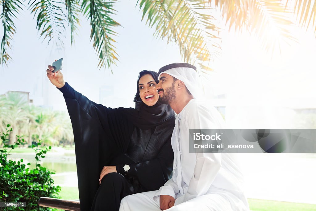 Traditional Emirati young family taking a selfie Traditional Emirati young family taking a selfie. Shoot from Istockalypse Dubai 2015.  2015 Stock Photo