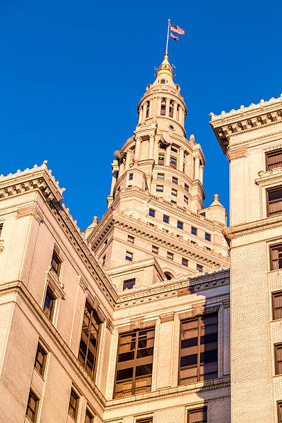 tall stone and brick building with flag on top Tall brick and stone building with Cornus features and ornamental stone with circular top and flag on top terminal tower stock pictures, royalty-free photos & images