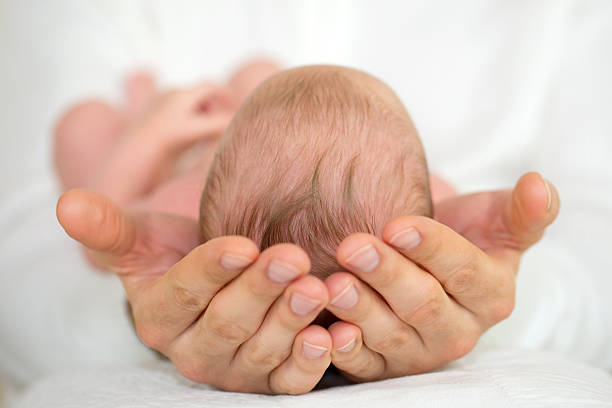 istock Men's Hands holding newborn baby. 469544501