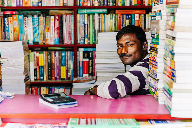 India: Kolkata College Street Second-hand Book Market Kolkata, India - March 6, 2014: Man selling used books at the largest second-hand book market in the world on College Street in Kolkata, India india indian culture market clothing stock pictures, royalty-free photos & images