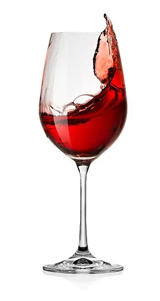 Photo of Glass of red wine splash over white background