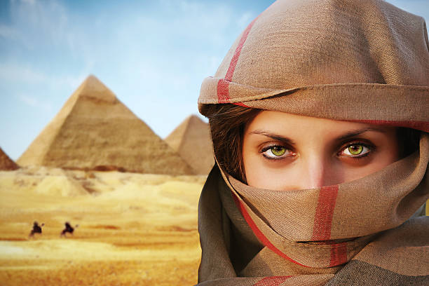 beautiful green eyed woman in chador, in the backgrond are pyramids