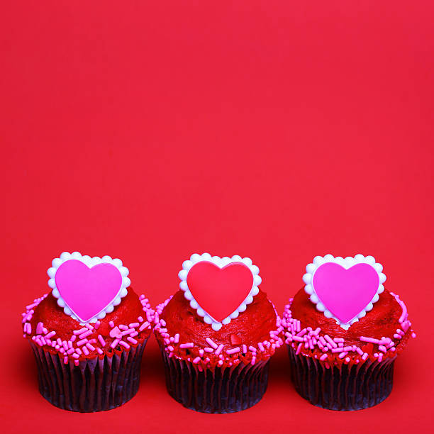 istock Chocolate cupcakes with Valentine hearts on the tops, over red 469547883