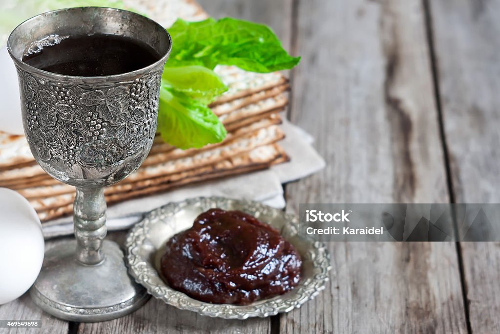 Passover background Wine, egg, bitter salad leaves, matzot and haroset - traditional jewish passover celebration elements. Copy space background. 2015 Stock Photo