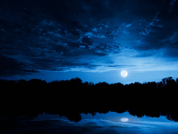 istock Dramatic Moonrise With Deep Blue Sky Lake Reflections and Clouds 469550457