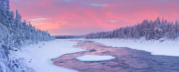 Sunrise over river rapids in a winter landscape, Finnish Lapland A rapid in a river in a wintry landscape. Photographed at the Äijäkoski rapids in the Muonionjoki river in Finnish Lapland at sunrise. snowy river stock pictures, royalty-free photos & images