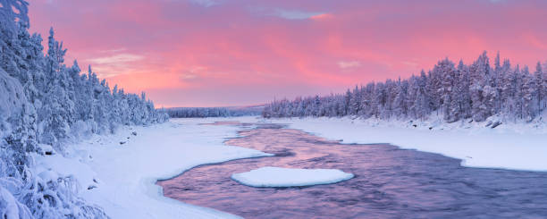 Sunrise over river rapids in a winter landscape, Finnish Lapland A rapid in a river in a wintry landscape. Photographed at the Äijäkoski rapids in the Muonionjoki river in Finnish Lapland at sunrise. snow river stock pictures, royalty-free photos & images