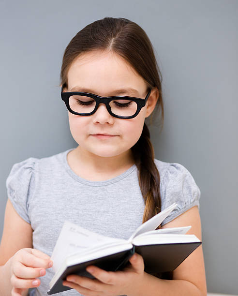 istock Little girl is reading a book 469552563