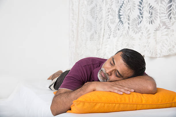 Middle Age Adult sleeping  on bed stock photo