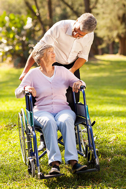 istock middle aged son taking his disabled mother for a walk 469555051