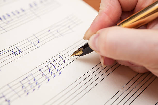 istock Hand with pen and music sheet 469555431