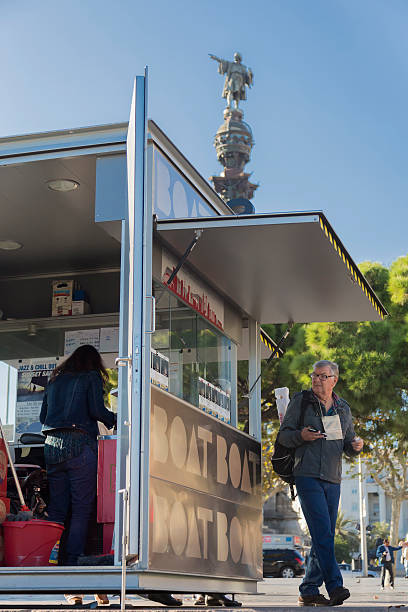 Barcelona, Port Vell - tourist passing by golondrina ticket booth stock photo