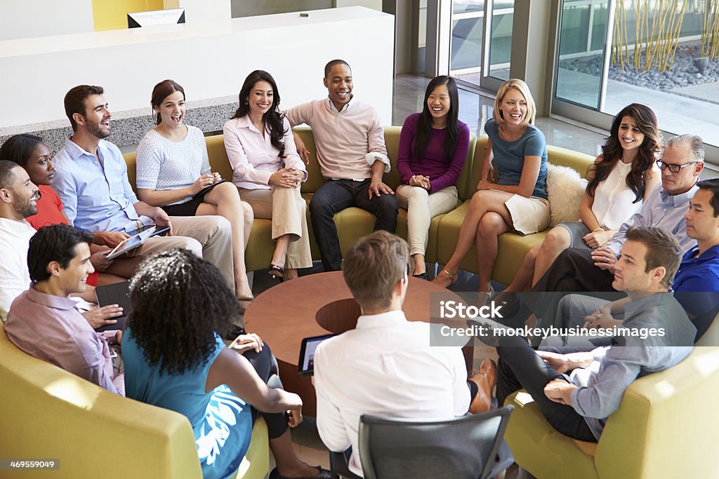 Multi-Cultural Office Staff Sitting Having Meeting Together Multi-Cultural Office Staff Sitting Having Meeting Together In Smart/Casual Dresswear Discussion Stock Photo