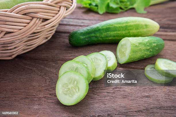 Fresh Cucumber And Slices On Wooden Table Stock Photo - Download Image Now - 2015, Basket, Chopped Food
