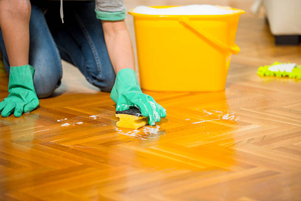 istock Woman cleaning the floor while kneeling at home 469561520