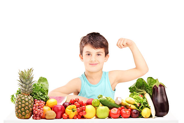istock Healthy child showing his muscles and sitting on a table 469564081