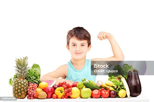 Healthy Child Showing His Muscles And Sitting On A Table Stock Photo - Download Image Now