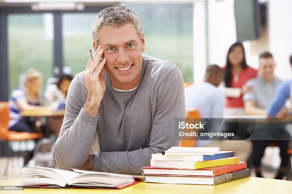 Male Mature Student Studying In Classroom With Books Male Mature Student Studying In Classroom With Books Smiling At Camera Education Stock Photo