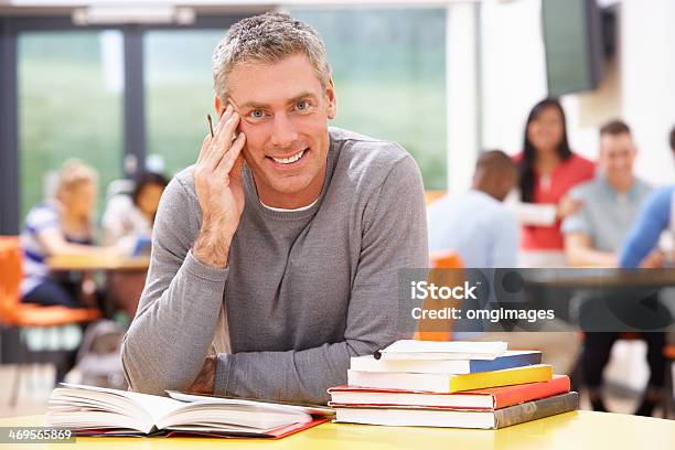 Male Mature Student Studying In Classroom With Books Stock Photo - Download Image Now