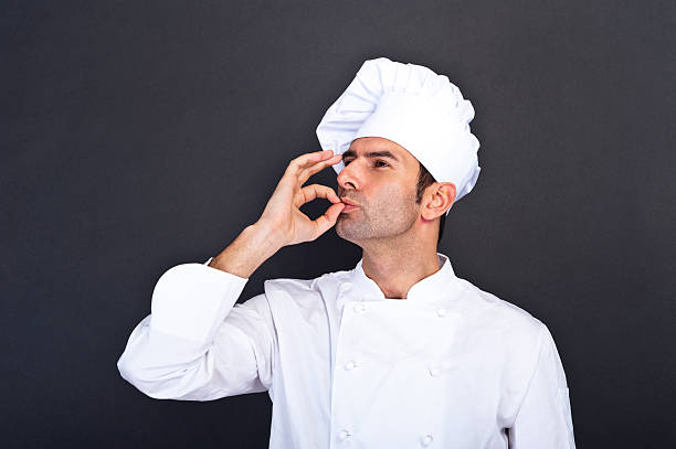 istock Male chef kissing fingers against grey background 469567215