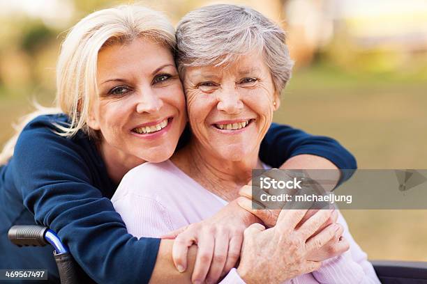 Middle Aged Woman Embracing Disabled Senior Mother Stock Photo - Download Image Now - Senior Adult, Mother, Adult Offspring