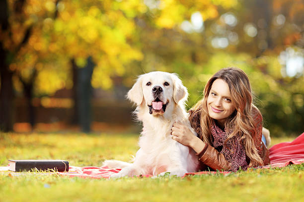 schöne weibliche liegen mit ihren hund im park - dog puppy lying down looking at camera stock-fotos und bilder