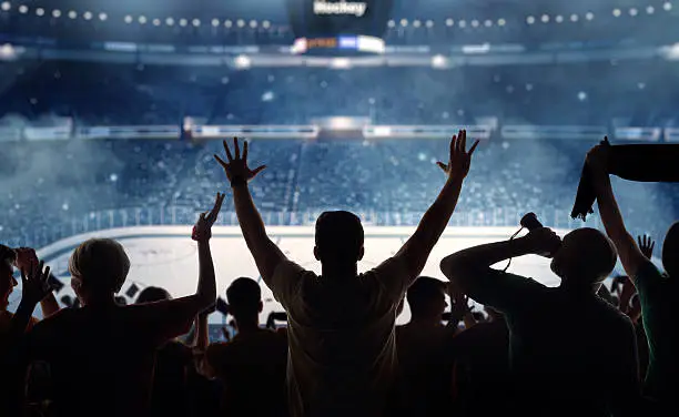 Hockey fans celebrating at a hockey game. We see their silhouettes and fans attributes