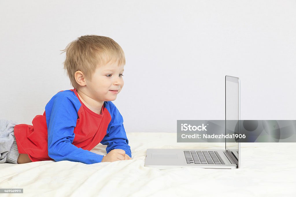 Petit garçon avec ordinateur portable à la maison - Photo de Activité de loisirs libre de droits
