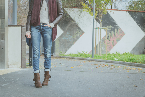 Detail of a young woman with jeans posing in the street