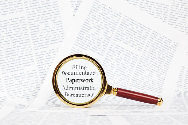 istock Paperwork and Magnifying Glass Concept 469574119